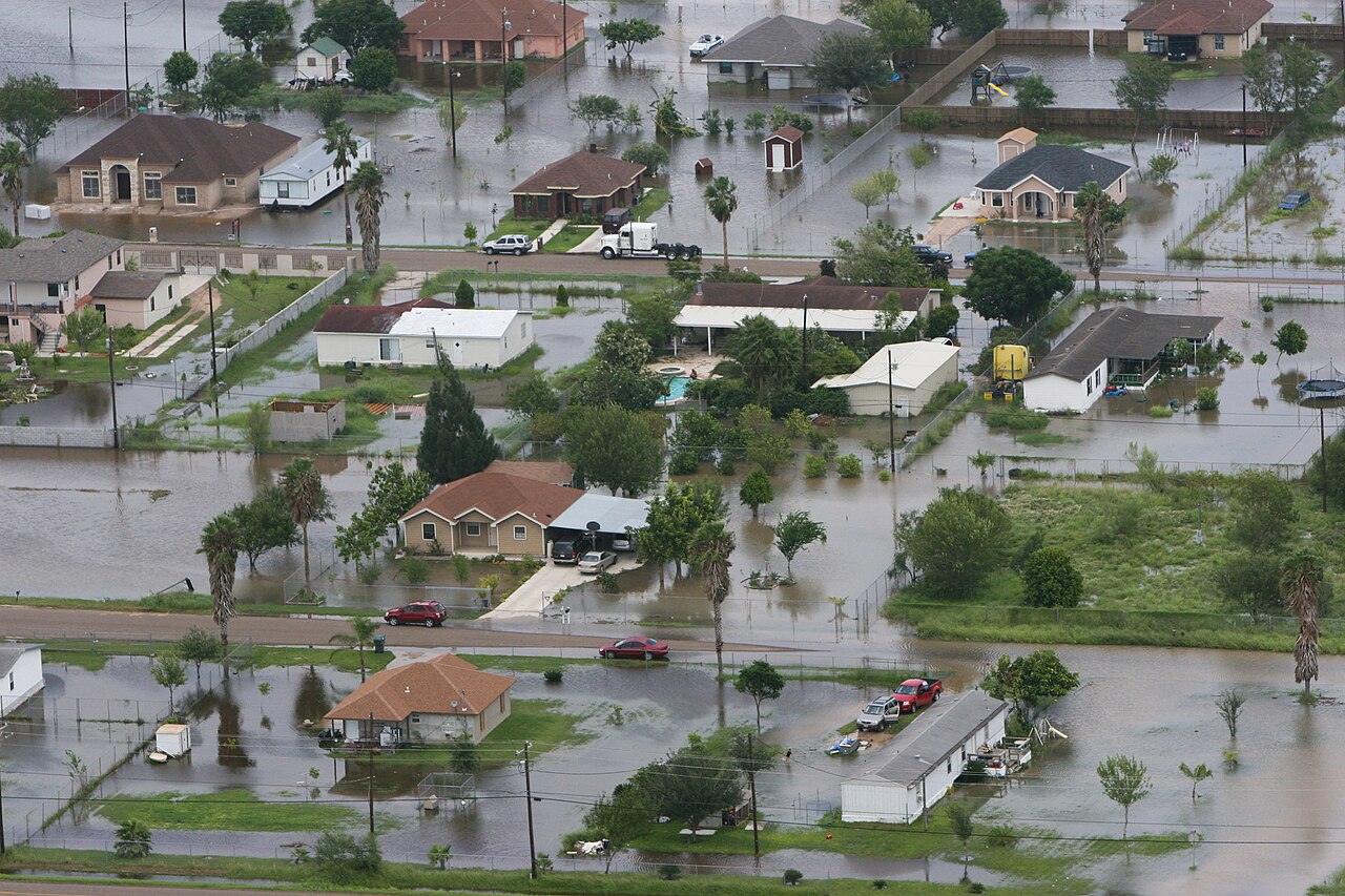 Aerial view of a flooded residential neighborhood with homes surrounded by floodwater
