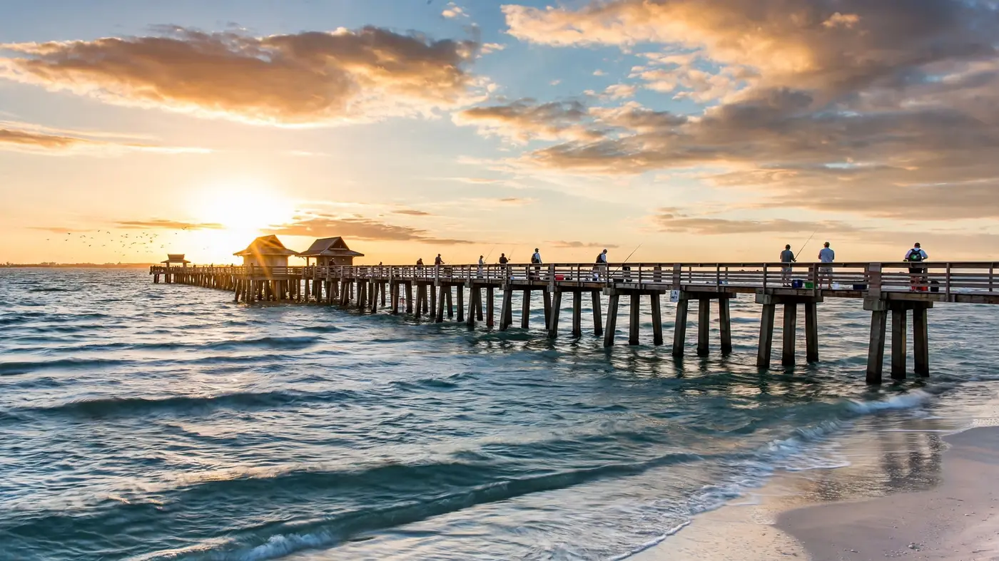 Water damage restoration in Arcadia, FL: a fishing pier stretching into the Gulf at sunset with anglers